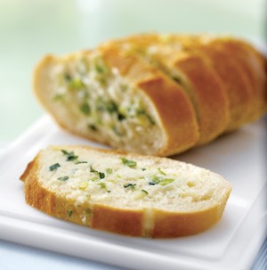 Sliced bread topped with fresh herbs and melted cheese