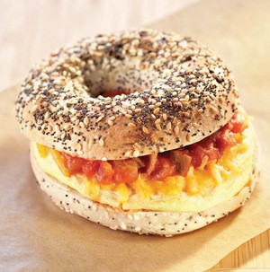 Egg, cheese and salsa sandwiched between a sliced everything bagel