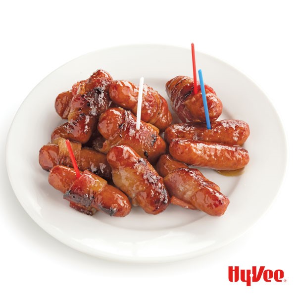 Plate of brown sugar, bacon-wrapped little smokies attached to red, white and blue toothpicks