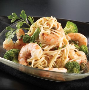 Spaghetti topped with shrimp, parsley, and broccoli 