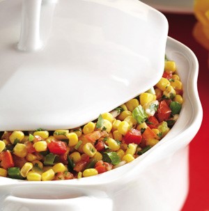Corn kernels with bell peppers and green onions in a casserole dish