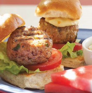 Mini burger buns topped with lettuce, sliced tomato, and grilled turkey patty