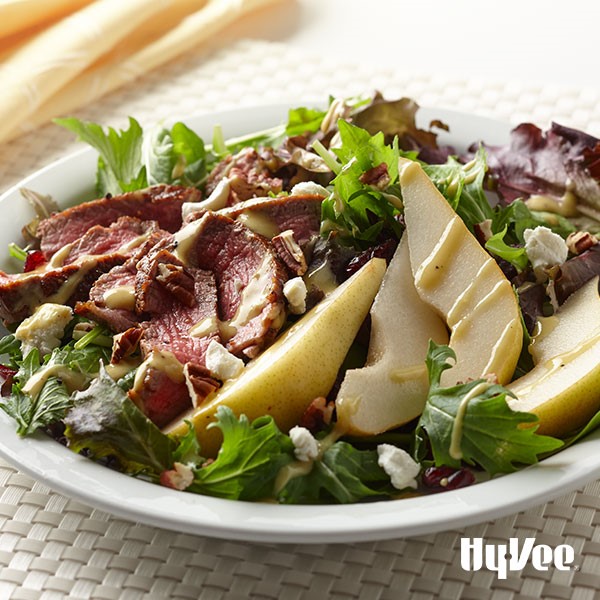 Mixed greens topped with sliced beef tenderloin, chopped pecans, crumbled cheese, dried cranberries, and sliced skin-on pears