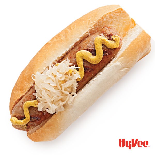 Brat and bun topped with mustard, onions and sauerkraut