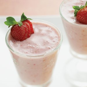 Glass filled with red smoothie and garnished with fresh strawberry