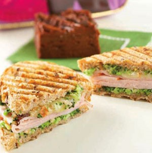 Sliced turkey grilled paninis  filled with vegetables, cheese, and broccoli