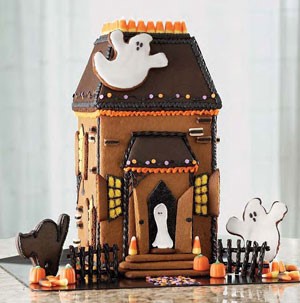 Gingerbread house decorated with candy corn and ghost cookies