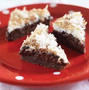 Chocolate brownies topped with shredded coconut on a red plate