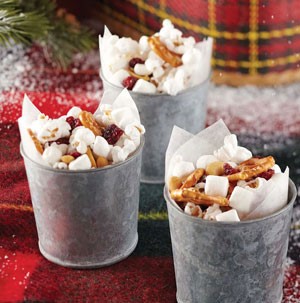 Tins holding popcorn, marshmallows, dried cranberries and pretzels