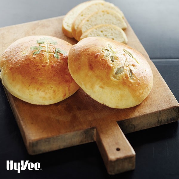 Bread topped with various whole spices on wooden cutting board