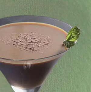 Chocolate martini topped with chocolate powder and garnished with a fresh mint leaf