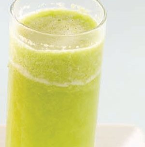 Tall glass filled with green apple and kiwi popper drink