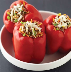 Stuffed red bell peppers with shredded carrots and melted cheese