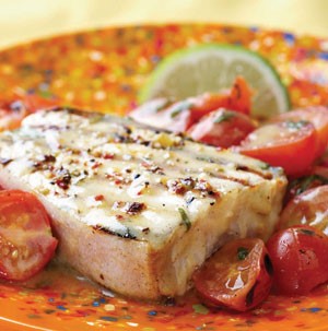 Grilled halibut with grilled halved tomatoes on the side