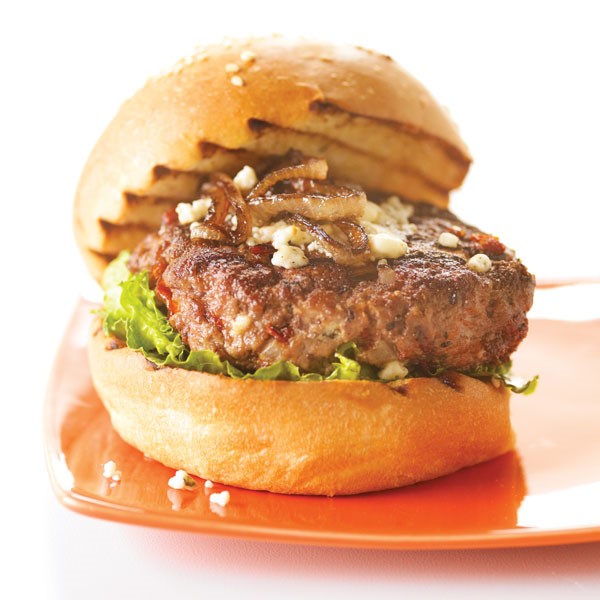 Burger on a grilled bun with crumbled gorgonzola and onions