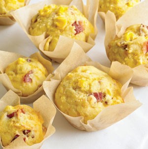 Yellow corn muffins stuffed with bacon and cheese in parchment cups