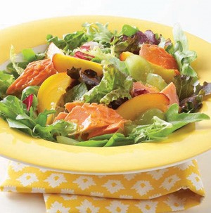 Nectarine and salmon topped salad with mixed greens