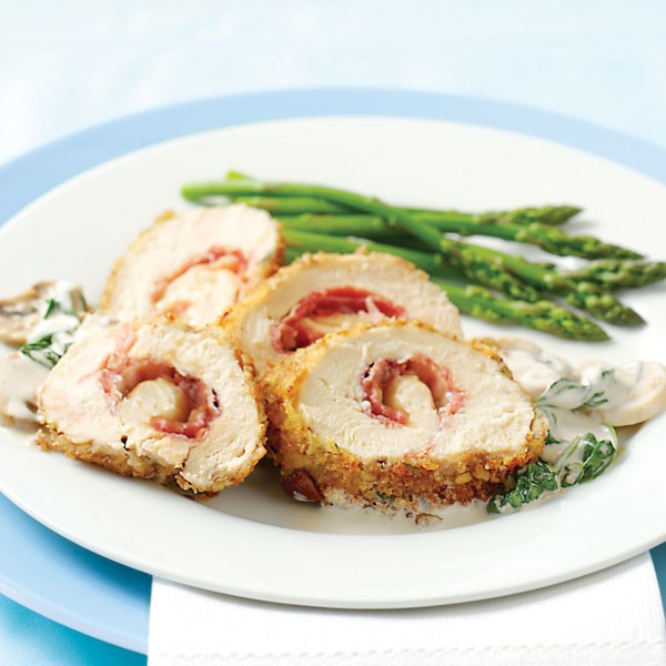 Chicken stuffed with pecan-crusted prosciutto with a cream sauce and a side of asparagus