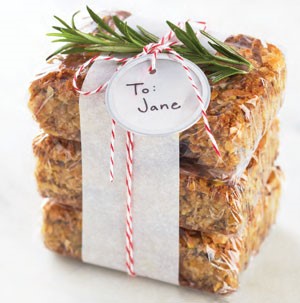 Chewy Oatmeal-Cherry Bars stacked and wrapped together with string and sprig of Rosemary