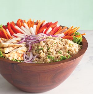 Bowl of quinoa topped with chicken, red onion, red bell pepper, carrots and jicama