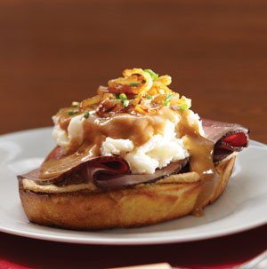 Bread topped with roast beef, mashed potatoes, gravy, and onions