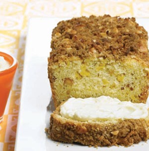 Mango macadamia loaf sliced and topped with cream cheese
