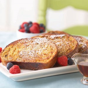 Thick cut French toast garnished with fresh berries and sprinkled with powdered sugar