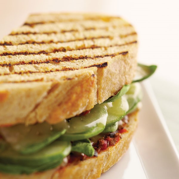 Grilled panini filled with olive tapenade, sliced cheese, spinach and cucumber slices