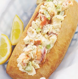 Rolls filled with lobster meat and a creamy sauce with two lemon wedges on the side