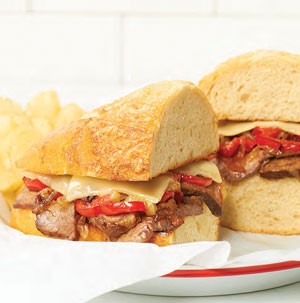 Plate of philly cheese steak with side of chips