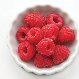 Circular dish filled with whole fresh raspberries