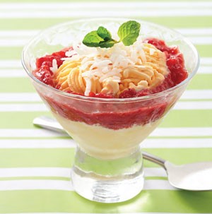 Cup filled with vanilla ice cream and smashed strawberries, and topped with shredded coconut and a mint leaf