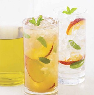 Glass of iced tea, garnished with peach slices and mint leaves