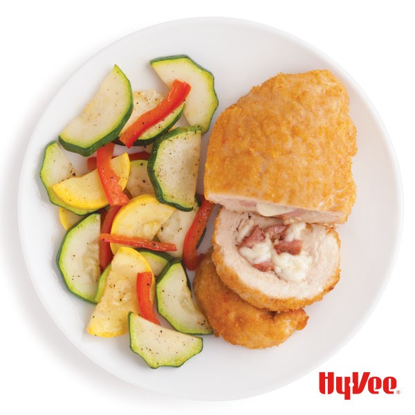 Plate of baked chicken cordon bleu with squash and zucchini
