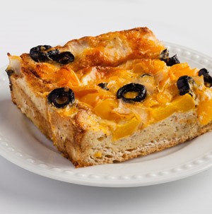 Crust topped with cheese and sliced black olives on a white plate