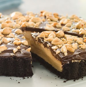 Peanut butter pie topped with chocolate frosting and garnished with peanuts
