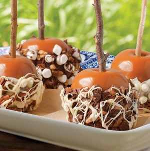 Plate of Caramel Apples on a Stick covered in Milk and White Chocolate, Marshmallows, Heath bar, Walnuts and Pecans