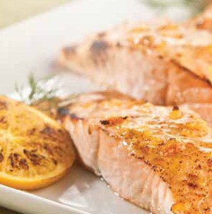 Plate of salmon fillets topped in an orange citrus sauce