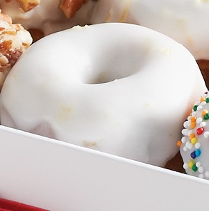 Blueberry mini donut topped with white lemon glaze in a box