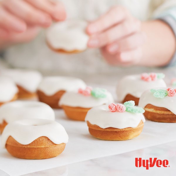 White confectioner's glaze on top of donuts on parchment paper