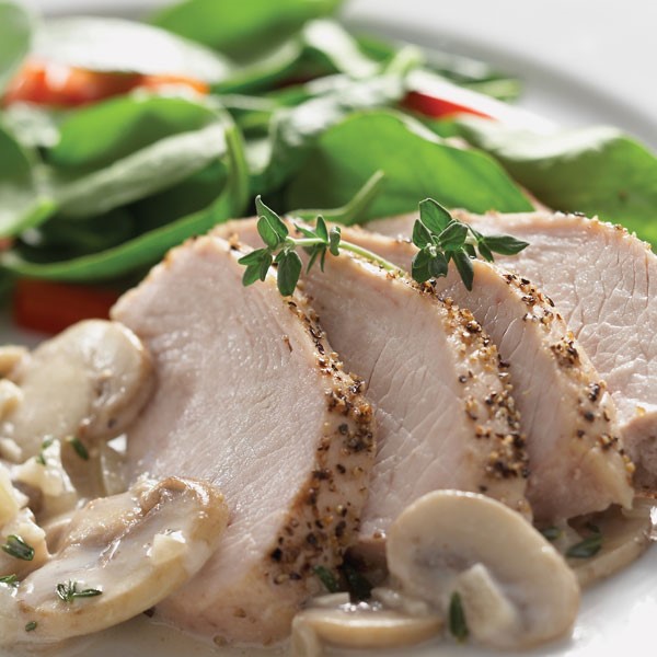 Spice rubbed sliced turkey tenderloin with mushroom cream sauce and fresh thyme for garnish