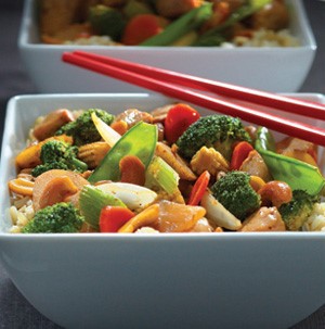 Bowl of spicy cashew chicken mixed with broccoli, celery, carrots, onion and snow pea Pods