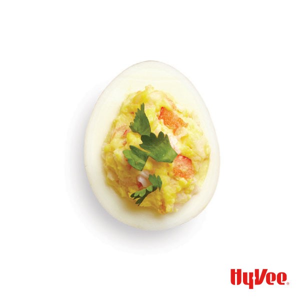 Deviled egg filled with chunks of shrimp and garnished with cilantro