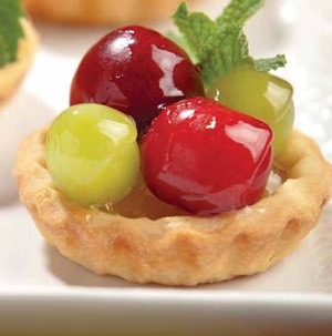 Pie crust topped with glazed fresh grapes and fresh mint leaves