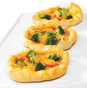 Mini pizzas topped with broccoli and cheese
