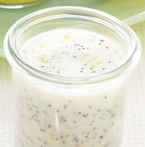 White vinaigrette with lemon zest and poppy seeds in a small glass