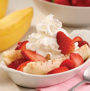 Bowl of berry banana split topped with whipped cream