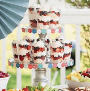 Glasses filled with layers of whipped cream and berries on a cupcake tower