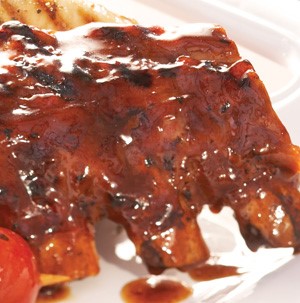 Grilled ribs covered in barbecue sauce