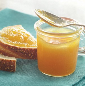 Jar of honey next to sliced bread with honey spread